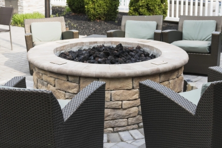 Close-up of a hardscape fire pit with paver patio and gravel drainage in North Carolina